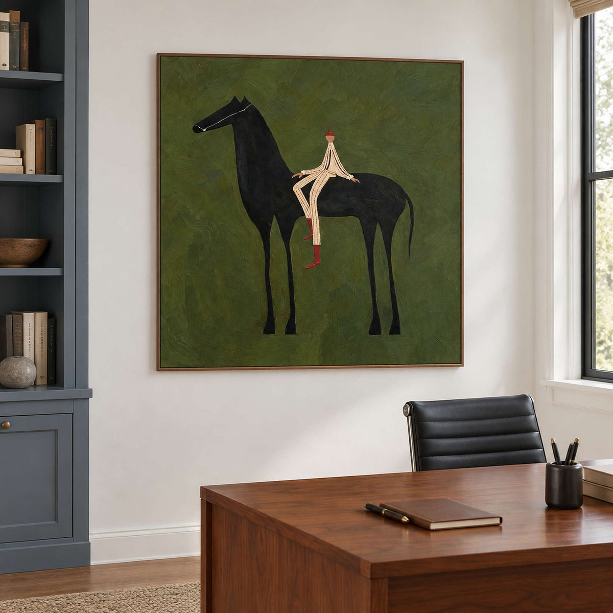 Square equestrian artwork beside blue-gray bookshelves above a study desk.