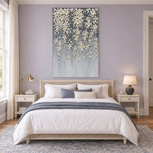 White blossom artwork above a bed against a lilac wall.