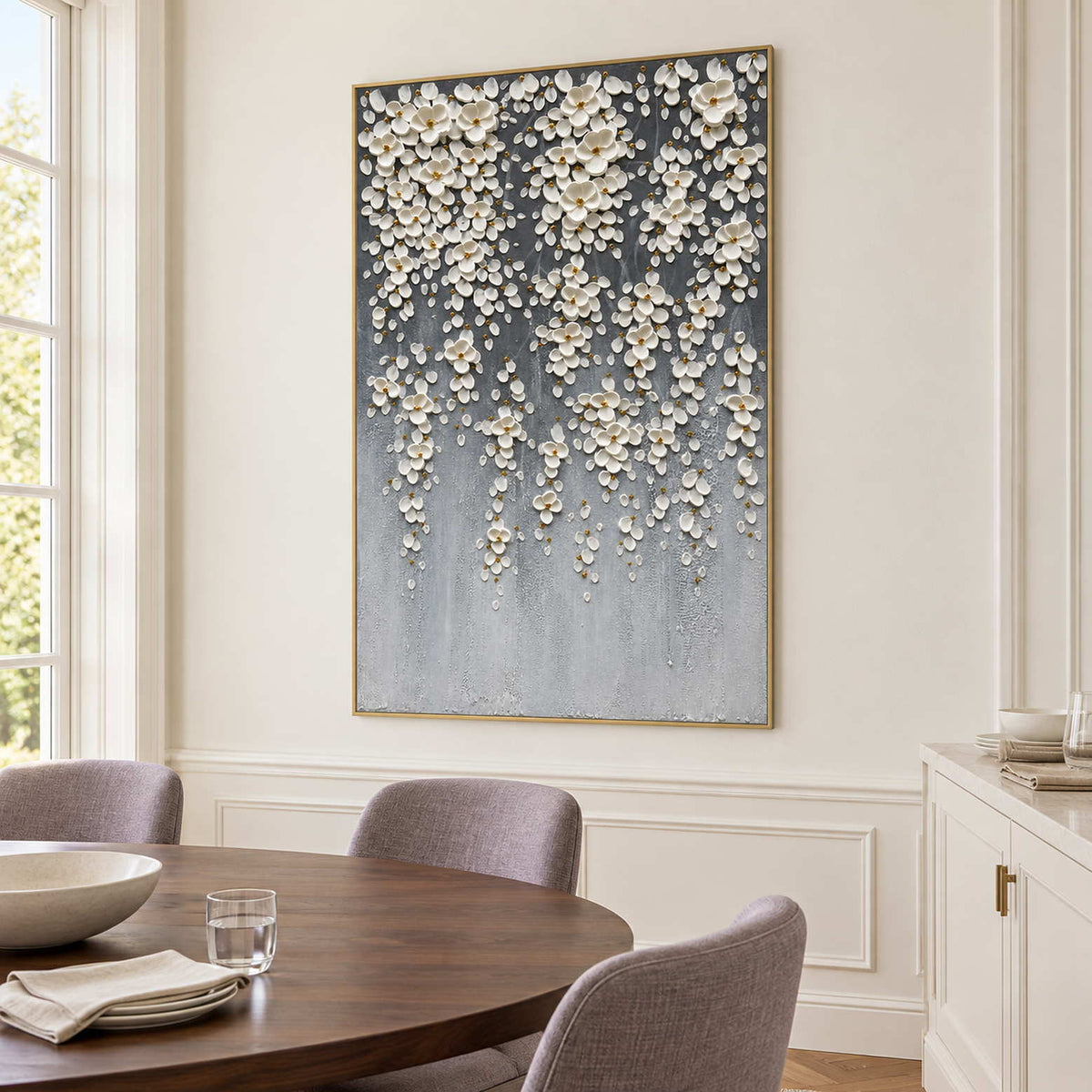 Cascading blossom art beside a round wooden dining table.