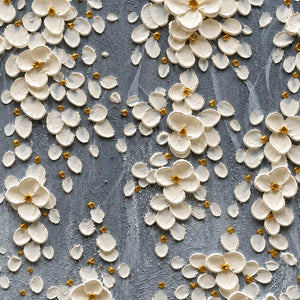 Close-up of cupped white petals, gold-colored centers, and gray surface texture.