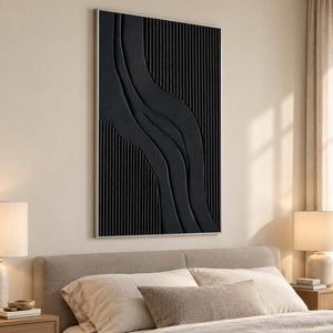 Black S-curve artwork above a beige bed with pale cushions and bedside lamps.