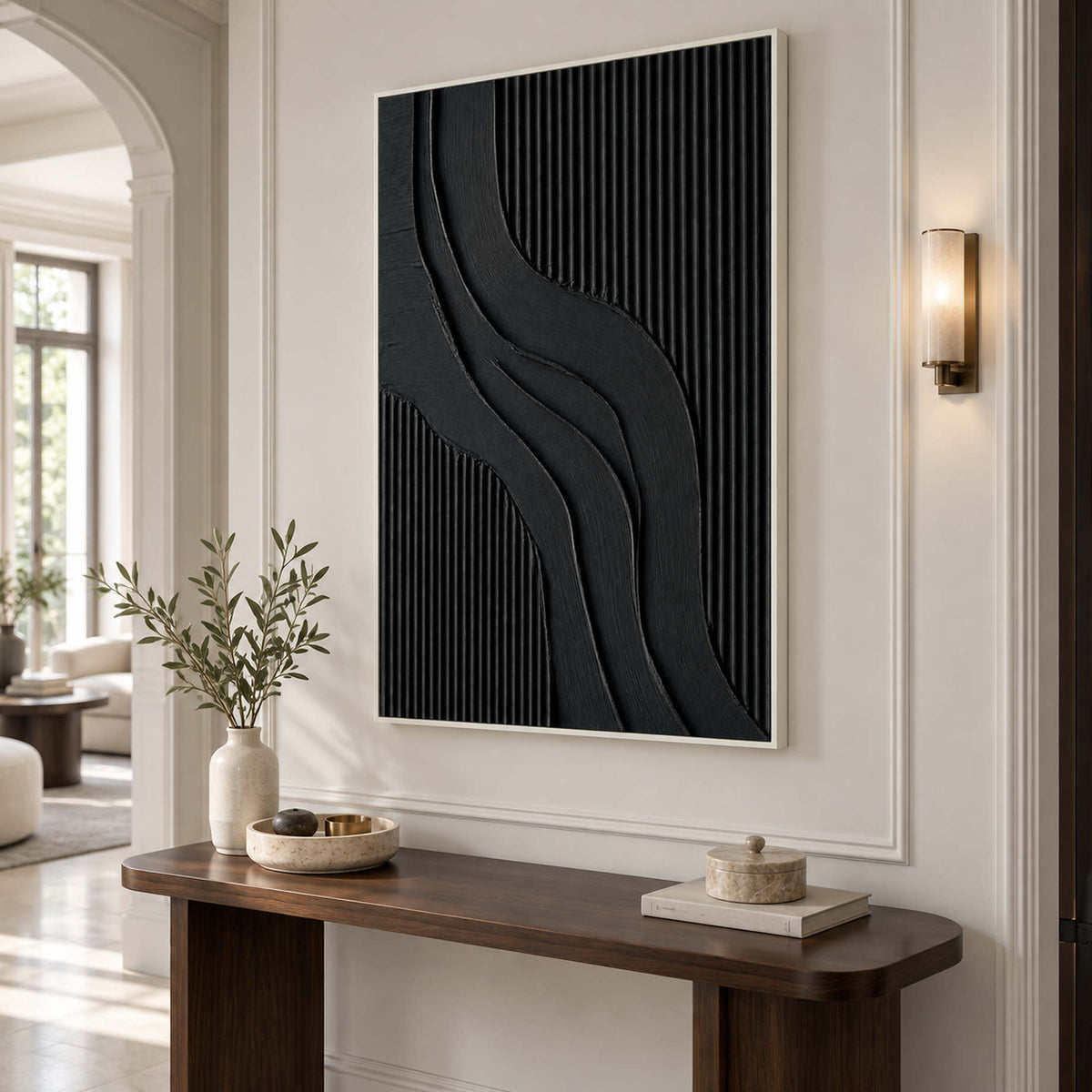 Curved black abstract over a narrow dark console beneath a wall light.