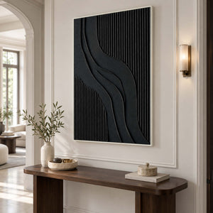 Curved black abstract over a narrow dark console beneath a wall light.