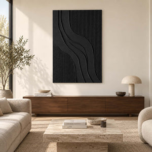 Black curved-ridge abstract above a long brown cabinet in a cream living room.