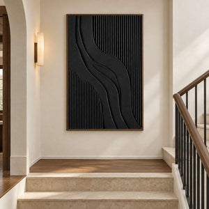 Black ridged abstract on a stair landing beside a wooden handrail.