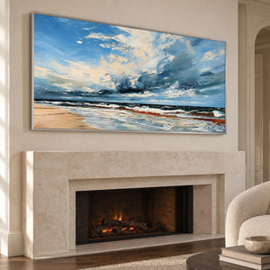 Wide sky and surf painting above a lit pale fireplace.