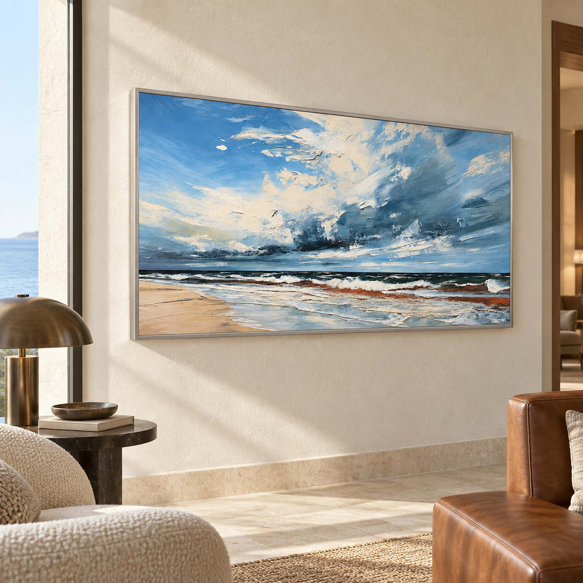 Blue and cream coastal painting beside a brown chair in a sunlit sitting room.