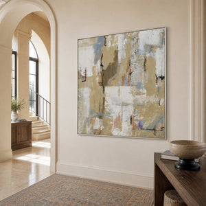 Silver-framed cream and blue-gray artwork beside an arched entryway leading to a bright staircase.