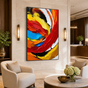 Black framed swirling abstract painting beside cream lounge chairs in a hotel lobby.