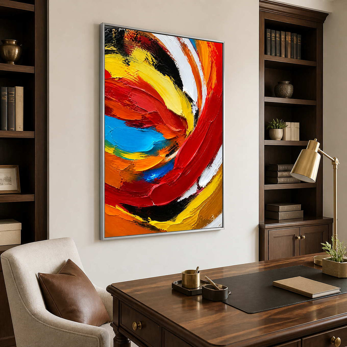 Silver framed swirling abstract painting behind a walnut desk and brown leather chair.