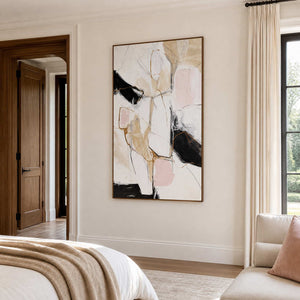 Wood framed abstract artwork beside a neutral bed and window seating.