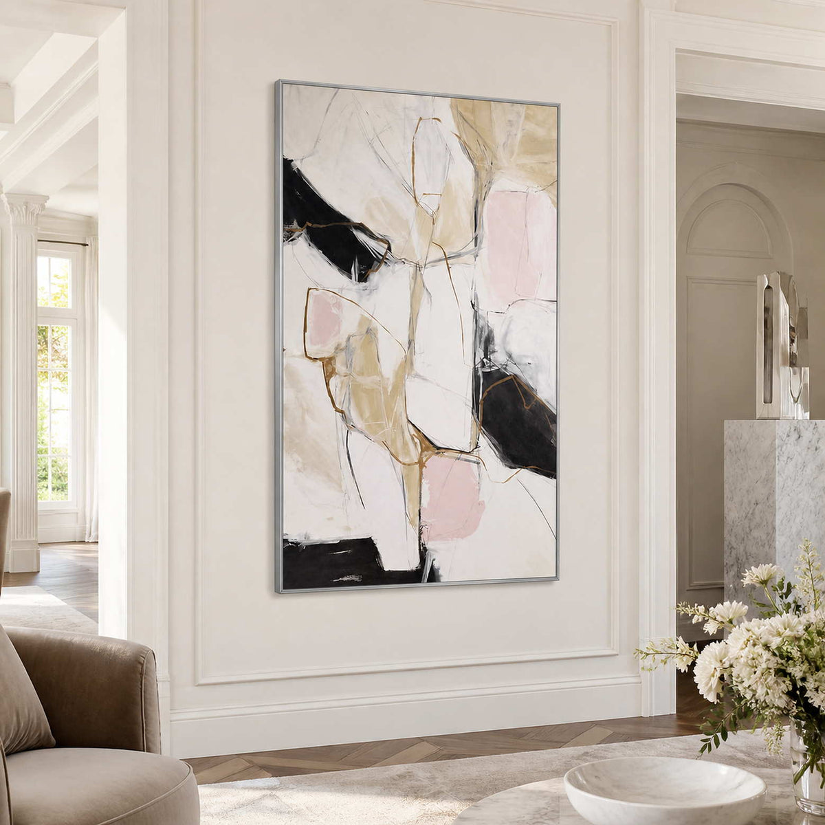 Silver framed blush and black abstract artwork on a bright paneled entryway wall.