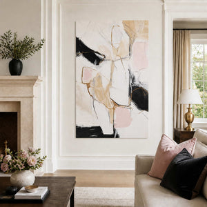 Frameless blush and black abstract artwork beside a fireplace and neutral sofa.