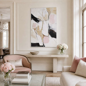 White framed abstract artwork above a console in a softly furnished sitting room.