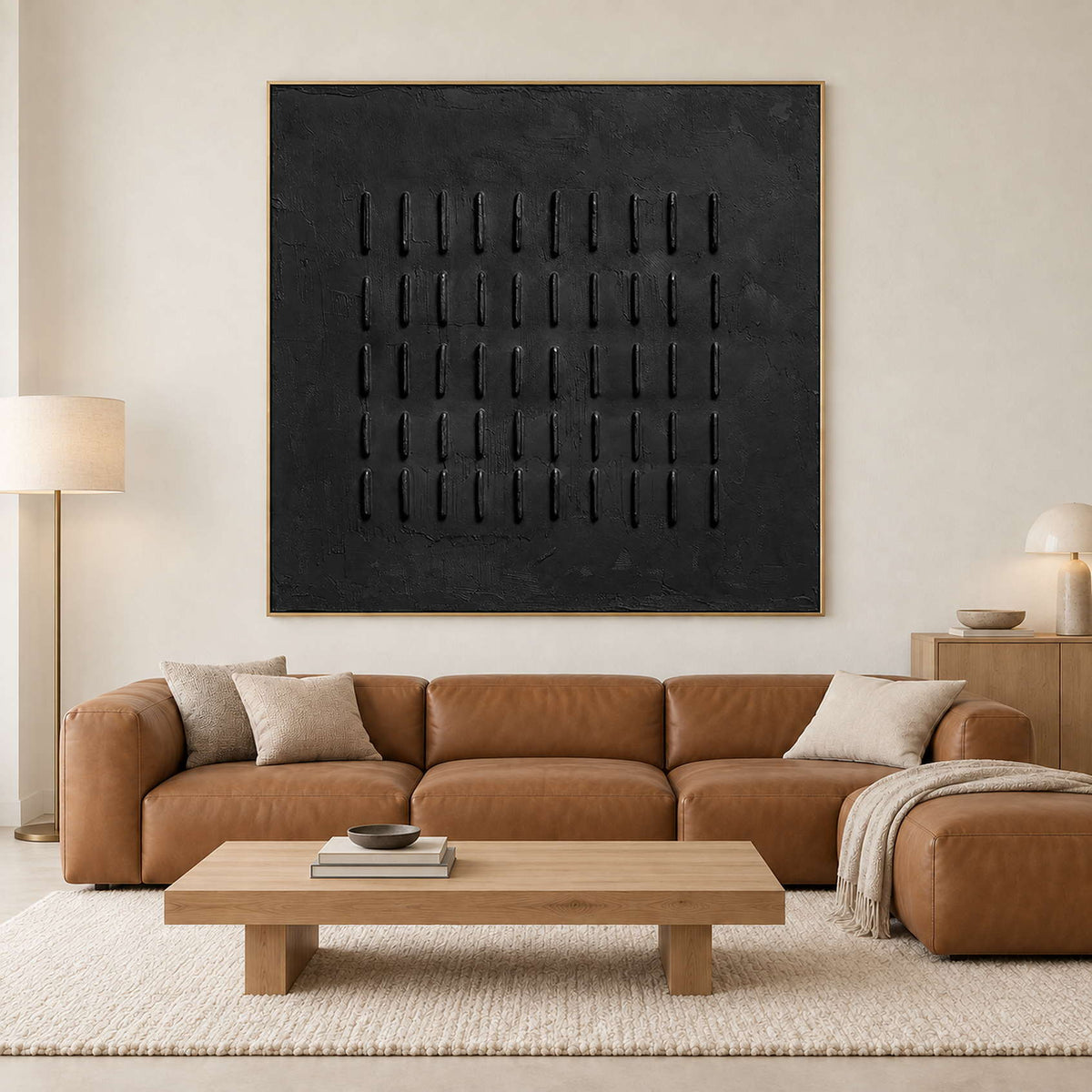 Black repeated-stroke painting above a tan leather sectional and light wood coffee table.