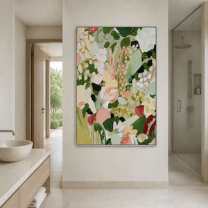 Silver framed floral painting between a bathroom vanity and glass shower enclosure.