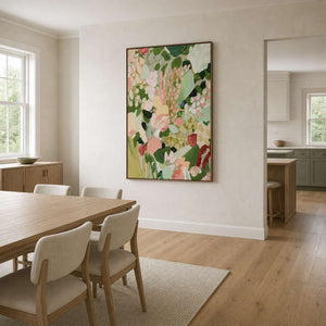 Walnut framed floral artwork beside a light wood dining table and cream chairs.