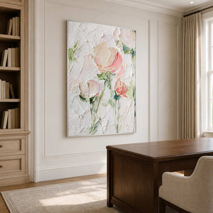 Silver framed floral artwork beside a wooden desk and bookshelves in a bright study.
