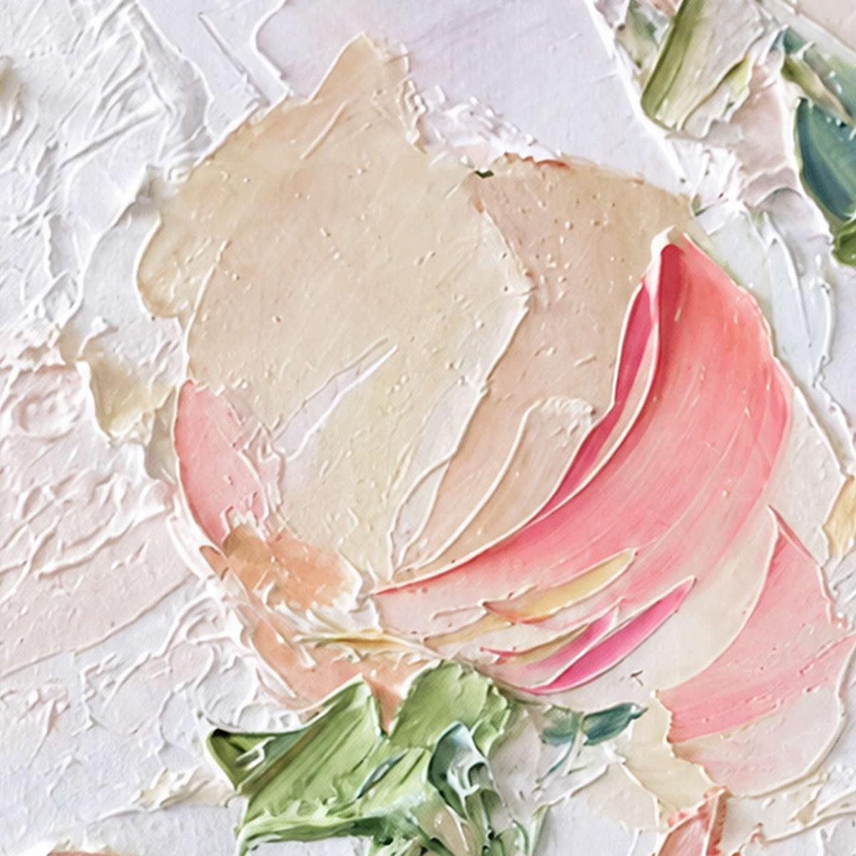 Close detail of raised cream and pink petals with green accents on white.