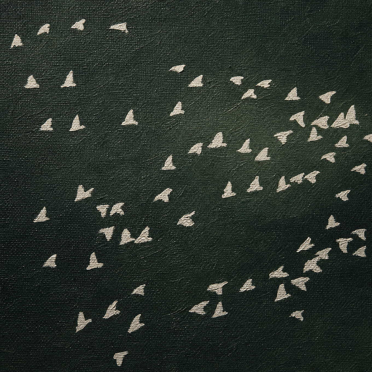 Close-up of ivory bird forms against layered forest-green texture.