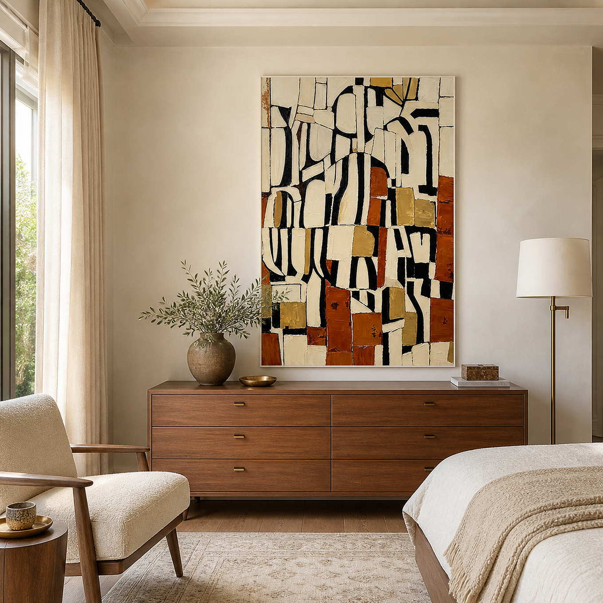 White framed geometric abstract painting above a wood dresser in a softly lit bedroom.