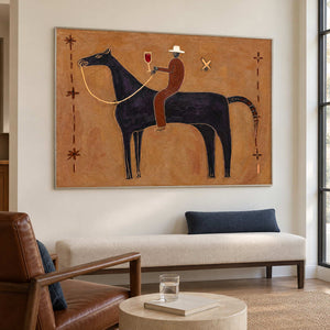 Angled equestrian artwork above a cream settee beside a window.