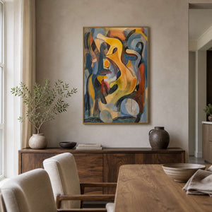 Gold framed colorful abstract painting above a wooden sideboard beside a dining table.