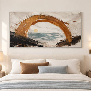 Hand-painted coastal abstract with a bronze arch sea-glass water and quiet sun, displayed in a bedroom in a silver frame.