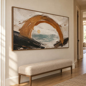 Hand-painted coastal abstract with a bronze arch sea-glass water and quiet sun, displayed in a hallway in a brown wood frame.