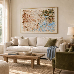 A Visit from Spring in a gold frame above a cream sofa and rustic wood coffee table beside an olive armchair.