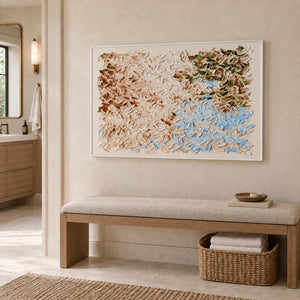 A Visit from Spring in a white frame above a cushioned bench with a towel basket in a bathroom dry area.