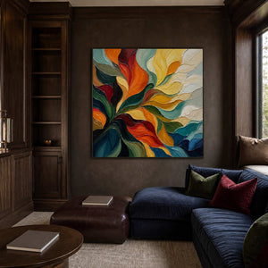 A Warm Embrace in a black frame above a dark upholstered sofa in a walnut-paneled study.