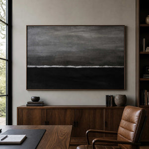 Wood framed monochrome wave artwork overlooking a leather chair and desk in an office.