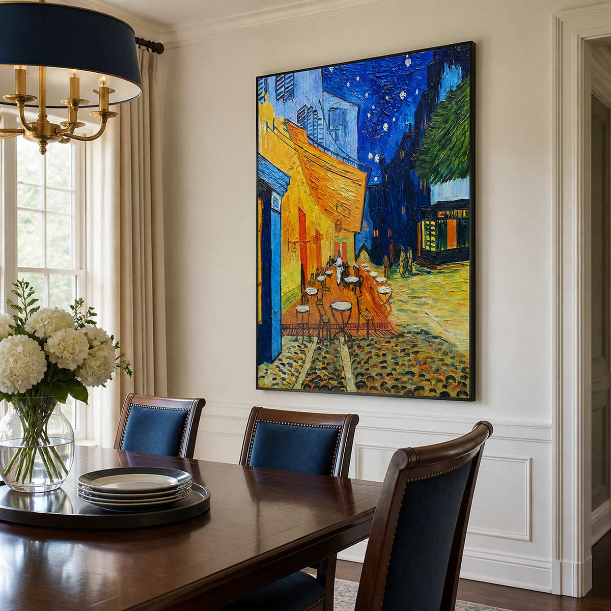 Black framed café painting above a dining table with navy upholstered chairs.