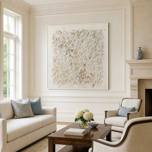 White-framed textured abstract wall art above cream seating and a wooden living room coffee table.