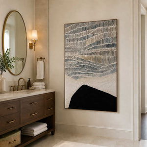 Wood framed textured abstract artwork beside a stone vanity in a bathroom dry area.