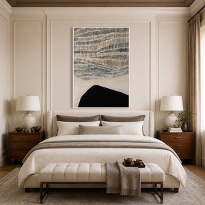 White framed gray and cream abstract artwork above a bed with neutral bedding.