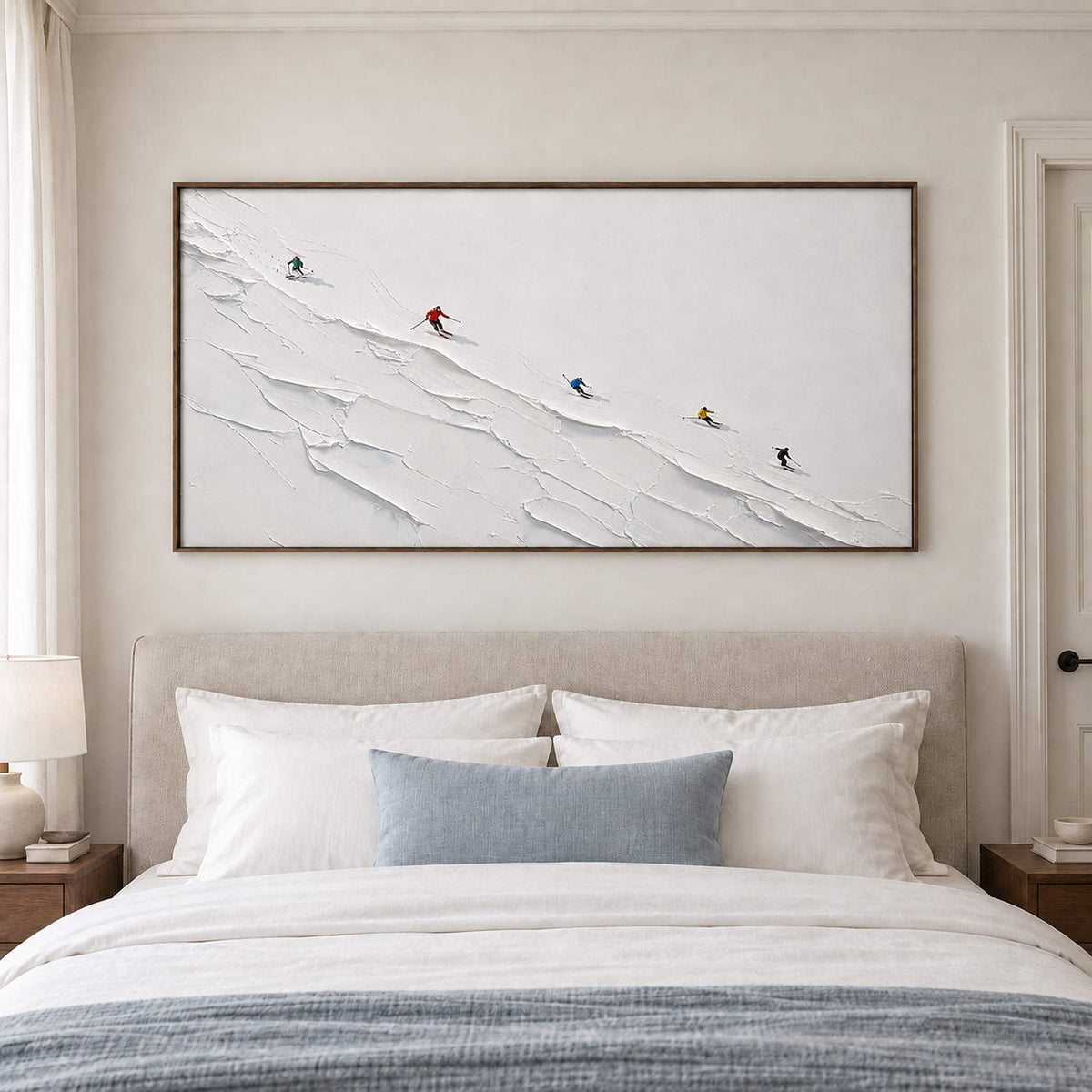 Tiny colorful skiers crossing a ridged white slope in a brown wood frame, displayed above a bed.