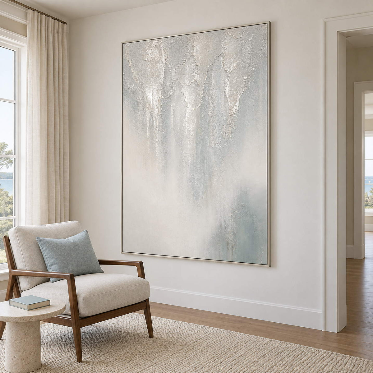 Soft gray and ivory vertical textures fading into pale blue in a silver frame, displayed beside seating in a lounge.