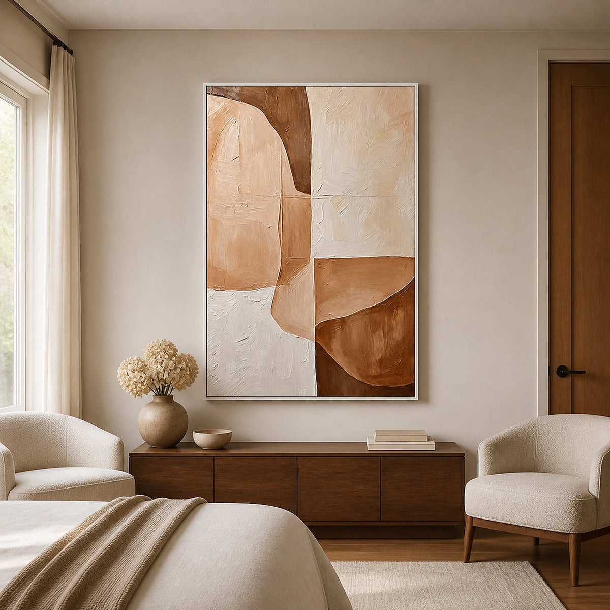 White-framed peach and cream abstract painting above a wooden cabinet facing a softly furnished bedroom.