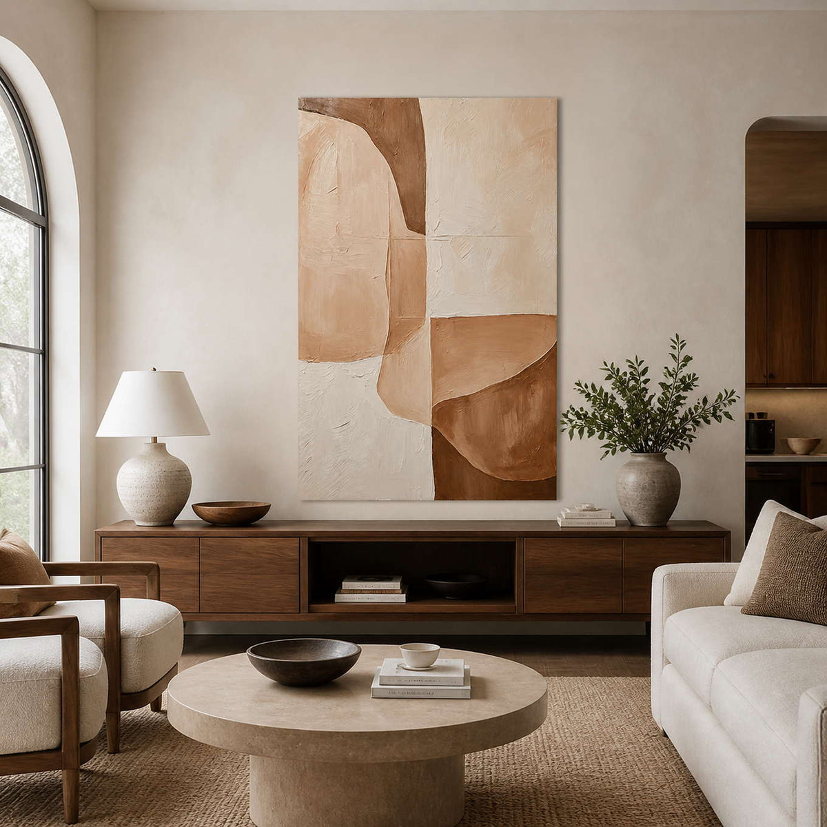 Warm cream and caramel abstract painting above a walnut cabinet in a sunlit living room with ivory seating.