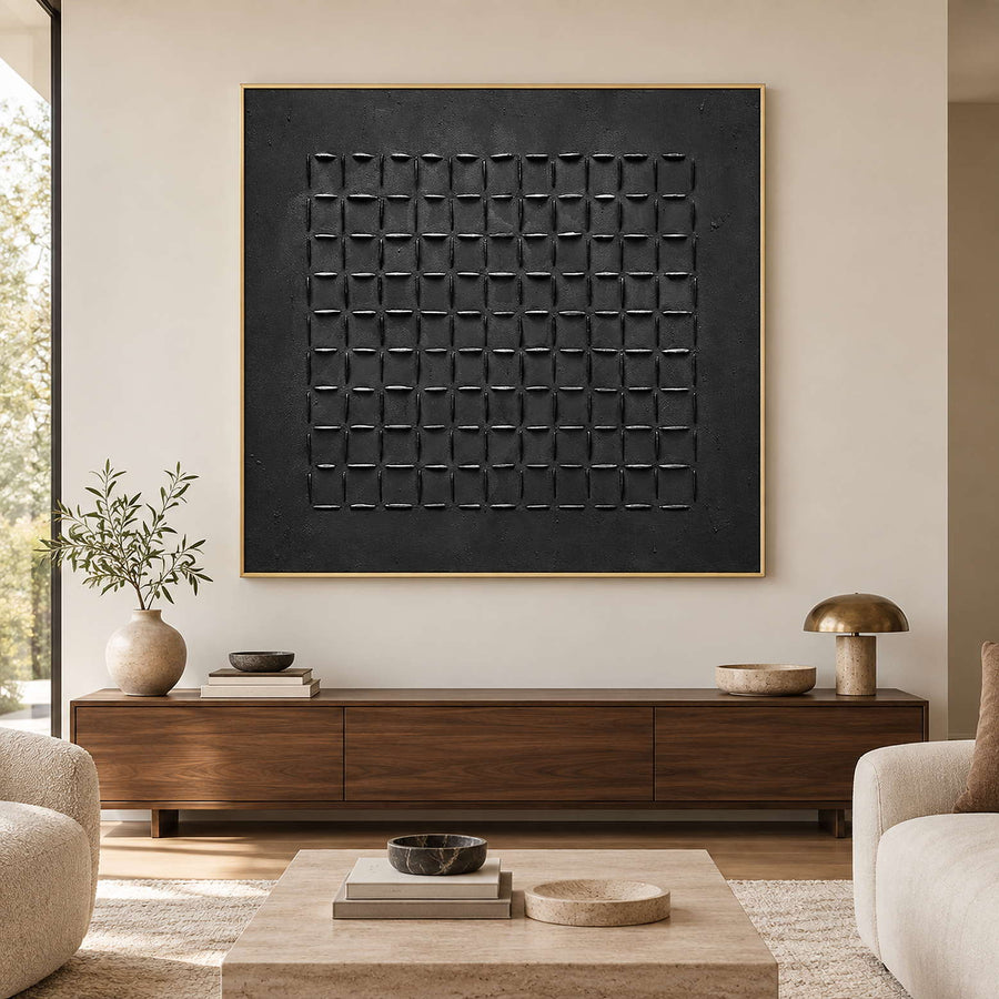 Black grid artwork in a gold-toned frame above a long wood living room cabinet.