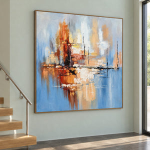 On a stair landing, an artwork with a brown wood-look frame shows amber and rust blocks crossing a dark horizontal line on pale blue.