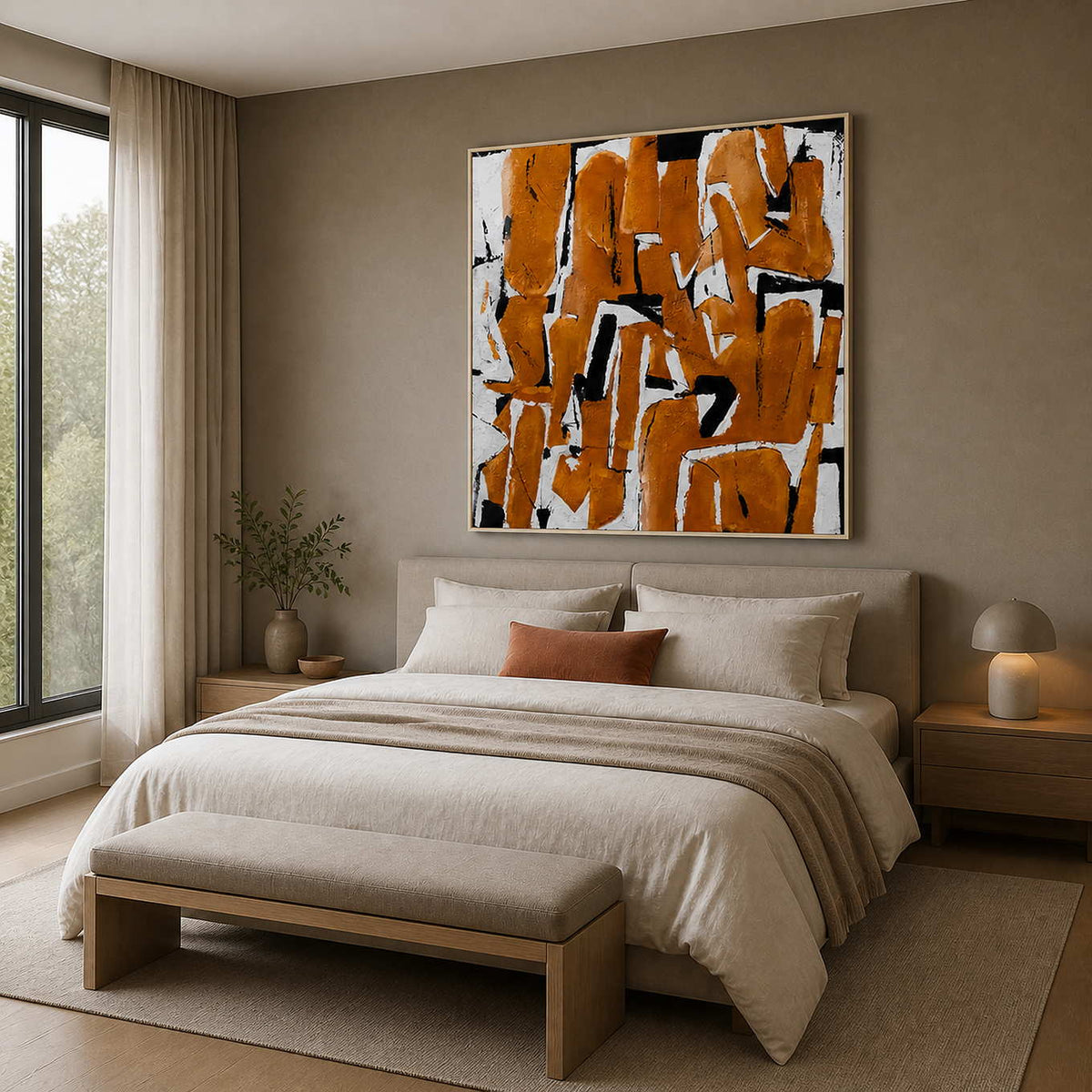 White-framed ochre abstract painting above a cream bed, viewed from the left side of a bright bedroom.