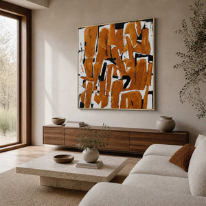 An Eager Embrace in a gold frame above a wood sideboard, bringing warm ochre strokes to a sunlit living room.