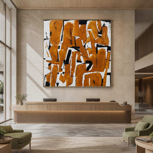 Silver-framed square abstract artwork above a light wood reception desk with pale green waiting chairs.