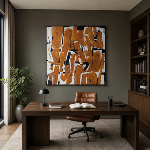 An Eager Embrace in a black frame above a wood desk and leather chair in a home study.