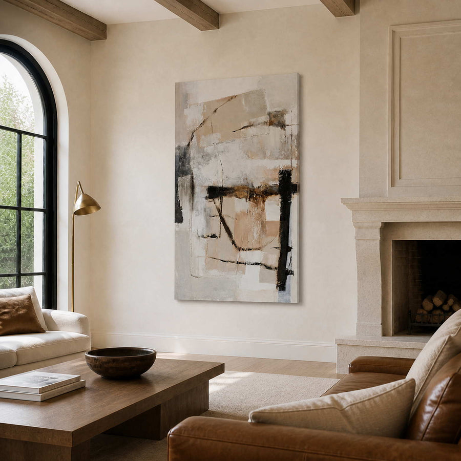 Frameless cream and beige abstract artwork beside a stone fireplace in a furnished living room.
