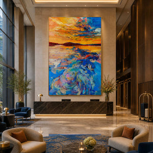 Gold framed orange and blue seascape above a dark stone hotel reception counter.