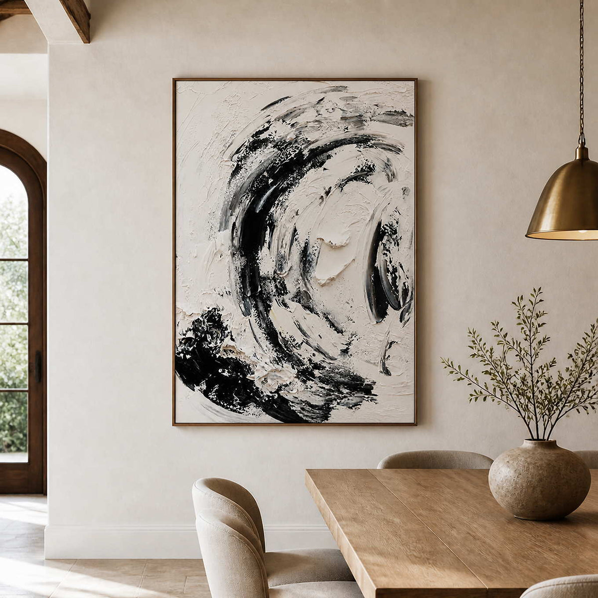 Wood framed black and white abstract painting beside a dining table beneath exposed ceiling beams.